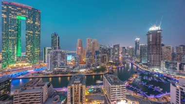 Dubai Marina Panorama 'sında limana park etmiş birkaç tekne ve yatlar ve kanal havası çevresindeki gökdelenler gece geçiş zamanına dönüşüyor. Arka planda JBR bölgesi kuleleri