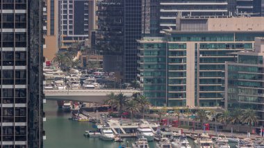 Birçok yat ve tekne liman havası zaman dilimine park edilmiştir. Dubai Marina rıhtımında birçok restoranı olan bir yürüyüş alanı. Modern tekne derede yüzüyor..
