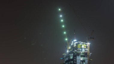 İnşaat zamanında inşa edilen yüksek katlı bir bina. Mavi gökyüzüne karşı vinçleri olan yer. Yeni gökdelen geliştirme