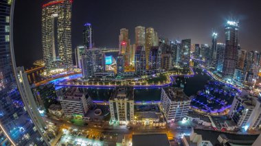 Dubai Marina Panoraması 'nda limana park edilmiş tekne ve yatlarla ve tüm gece boyunca kanalın çevresindeki gökdelenlerle aydınlandı. Arka planda JBR bölgesi kuleleri