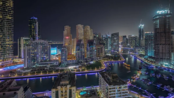 Panorama, Dubai Marina 'yı limana park etmiş birkaç tekne ve yatla gösteriyor. Kanal havası çevresindeki gökdelenleri aydınlatıyor. Arka planda JBR bölgesi kuleleri