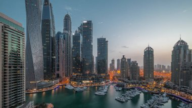 Dubai marinası en uzun gökdelenler ve yatlar liman havasında gece gündüz geçiş zamanları gün doğumunda. Apartman binalarına, otellere ve ofis bloklarına, BAE 'nin modern yerleşim alanlarına bak