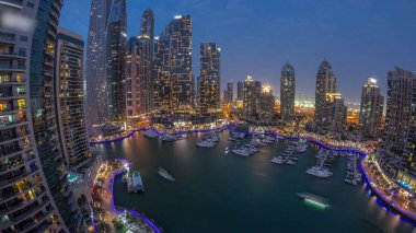 Dubai marinası en uzun gökdelenler panorama ve liman havasında yatlar gün batımından sonra gece geçiş zamanı. Apartman binalarına, otellere ve ofis bloklarına, BAE 'nin modern yerleşim alanlarına bak