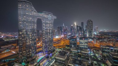 Fütürist Dubai Şehir Merkezi ve finans bölgesi gökyüzü gece zaman çizelgesi. Birçok aydınlık kule ve gökdelenler caddelerde trafik var.