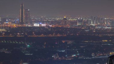 Deira ve Dubai deresi bölgesindeki evlerin ve otellerin hava manzarası. Tipik eski ve modern binaların gece zaman çizelgesi. Dubai, Birleşik Arap Emirlikleri