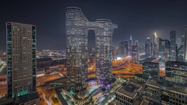 Panorama fütüristik Dubai şehir merkezini ve finansal bölge siluetini gösteriyor. Birçok aydınlık kule ve gökdelenler caddelerde trafik var.