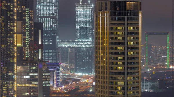 ドバイ国際金融センター地区のタワー航空夜のタイムラプス 高層ビルの建設中のオフィスビルやホテル 陸橋の上の交通 — ストック写真