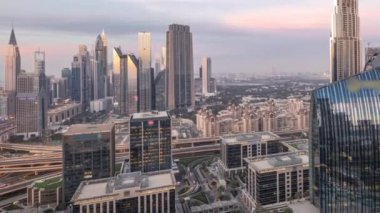 Fütürist Dubai Şehir Merkezi ve finans bölgesi silueti panorama havadan geceye geçiş zamanı. Birçok aydınlık kule ve gökdelenler caddelerde trafik var.