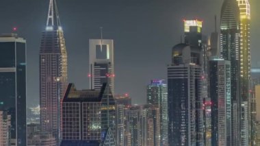 Dubai Finansal Merkezi 'nin gece saatlerinde aydınlatılan gökdelenleri var. Yoğun karayolu trafiği olan kulelere hava görüntüsü