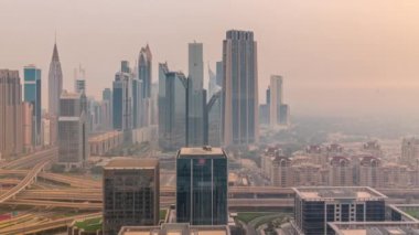 Dubai Finans Merkezi 'nin Panorama' sında uzun gökdelenler zaman ayarlı. Gün doğmadan önce sabah sisi olan işlek otoyol boyunca bulunan kulelerin hava görüntüsü