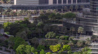 Şehir merkezine park et, metro bağlantısı üst geçidi ve yol zaman çizgisinde trafik var. Palmiyeler ve ağaçlarla hava manzaralı. Dubai, Birleşik Arap Emirlikleri