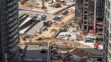 Vinçler, kazıcılar ve buldozerler yeni gökdelen hava zaman çizelgesinin şantiyesinde çalışıyorlar. Arazi temizliği, not verme, havuz kazma, siper kazma ve temel kazma. Sürüngen traktörü ve yer değiştirme ekipmanları