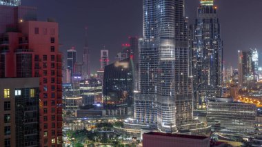 Şehir merkezinden tüm gece boyunca Dubai Uluslararası Finans Merkezi 'nin gökdelenlerinin hava görüntüsü. Aydınlatma kapalı camdan ofis kuleleri