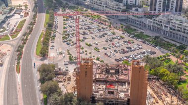 İş merkezinin park alanındaki arabaların hava manzarası, inşaat alanının yakınındaki tüm gün boyunca arabalı alışveriş merkezleri ve boş park yerleri. Gölgeler hızlı hareket ediyor