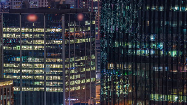 Night view of glowing windows in office building timelapse. High rise skyscraper with rows of lights in open space