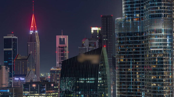Aerial view of Dubai International Financial Centre district skyscrapers night timelapse from downtown. Office towers from glass and hotels with modern buildings