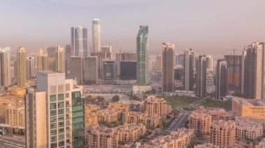 Akşam sıcacık ışıkta büyük, fütüristik bir şehrin panoramik silueti. Gökdelenleri ve geleneksel evleri olan iş sahası ve şehir merkezi bölgesi, Dubai, Birleşik Arap Emirlikleri