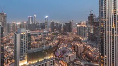 Büyük bir şehrin hava panoramik görüntüsü. Günbekten geceye geçiş zamanı. Dubai, Birleşik Arap Emirlikleri 'nin gökdelenleri ve geleneksel evleri olan iş sahası ve şehir merkezi..