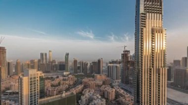 Gün batımında büyük, fütüristik bir şehrin göksel panoramik ufuk çizgisini gösteren panorama. Gökdelenleri ve geleneksel evleri olan iş sahası ve şehir merkezi bölgesi, Dubai, Birleşik Arap Emirlikleri