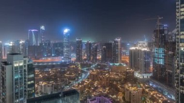 Gökdelenlerin ve geleneksel evlerin hava panoramik görüntüsü büyük, gelecekçi bir şehir gecesinde. İş sahası ve şehir merkezi bölgesi, Dubai, Birleşik Arap Emirlikleri silueti.