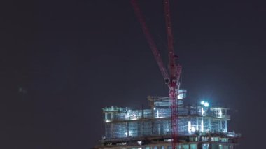 Büyük bina yapım aşamasında ve vinçler şehir merkezinde gece zaman diliminde. Yeni kulenin inşaat alanında çalışma devam ediyor