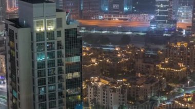 Gökdelenlerin ve geleneksel evlerin gece manzarası. İş sahası ve şehir merkezi bölgesi, Dubai, Birleşik Arap Emirlikleri silueti.