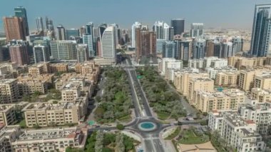 Barsha Heights bölgesindeki gökdelenler ve Greenens bölgesindeki alçak binalar. Dubai 'nin palmiyeler ve ağaçlarla kaplı panoramik silueti. Gölgeler hızlı hareket ediyor