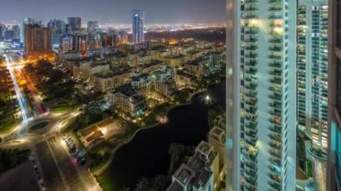 Barsha Heights bölgesindeki gökdelenler ve Greenens bölgesindeki alçak binalar gece panoramik zaman çizelgesi. Pencerelerinde ışıklar olan Dubai silueti