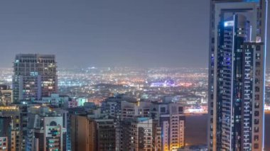 Barsha Heights bölgesindeki gökdelenler ve Greenens bölgesindeki alçak katlı binalar. Arka planda villa evleri olan Dubai silueti