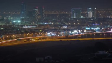 Dubai silueti, villa evleri ve arka plandaki hava zaman aralığında yeni kulelerin inşaat alanı. Yukarıdan boş alana sahip çöl yolu
