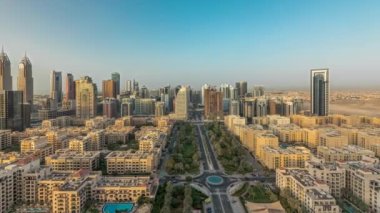 Barsha Heights bölgesindeki gökdelenleri ve Yeşiller bölgesindeki alçak binaları gösteren panorama. Palmiyeler ve ağaçlarla Dubai silueti