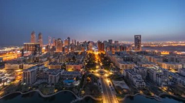 Barsha Heights bölgesindeki gökdelenler panoraması ve Greenens bölgesindeki alçak binalar gece gündüz geçiş zamanları. Aydınlatılmış caddelerde trafik olan Dubai silüeti