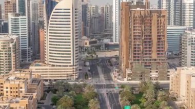 Barsha Heights bölgesindeki gökdelenler ve Greenens bölgesindeki alçak binalar. Yol boyunca palmiyeler ve ağaçlar olan Dubai silueti. Cami yakınlarında inşaat alanı