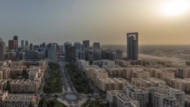 Barsha Heights bölgesindeki gökdelenler panoraması ve gün doğumundan itibaren Greenens bölgesindeki alçak katlı binalar. Dubai silueti Gölgeler hızla ilerliyor