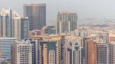 Barsha Heights bölgesindeki gökdelenler ve hava zaman çizelgesinin arkasındaki villalar. Kuleleri ve şantiyesi olan Dubai silueti