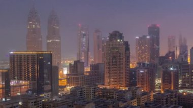 Barsha Heights bölgesindeki gökdelenler ve Greenens bölgesindeki alçak binalar gece gündüz geçiş zamanları. Dubai silueti ile internet şehri sabah sisi ile kaplı.