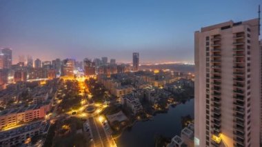 Barsha Heights bölgesindeki gökdelenler ve Greenens bölgesindeki alçak binalar gece gündüz geçiş zamanları. Dubai panoramik ufuk çizgisi sisli sabah