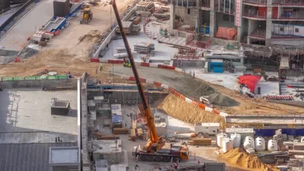 新しい超高層ビル空中タイムラプスの建設現場で働くクレーンやブルドーザー 土地の清掃 グレーディング プール掘削 ユーティリティのトレンチと基礎掘削 クローラートラクターと土 — ストック動画