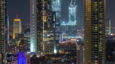 Dubai Uluslararası Finans Merkezi bölge gökdelenlerinin hava görüntüsü. Şehir merkezinden inşaat alanının zaman çizelgesi. Camdan ofis kuleleri ve modern binaları olan oteller.