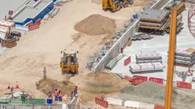 Kazıcılar ve buldozerler yeni gökdelen hava zaman çizelgesinin şantiyesinde çalışıyorlar. Arazi temizliği, not verme, havuz kazma, siper kazma ve temel kazma. Sürüngen traktörü ve toprak