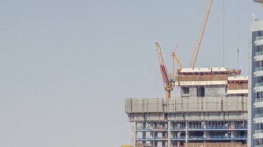 Vinçler modern kule zaman çizelgesinin arkasındaki yeni gökdelen üzerinde çalışıyorlar. Yüksek binaların ve bina faaliyetlerinin kentsel gelişimi