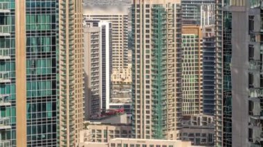 Şehir merkezindeki modern Dubai mimarisi ile havadan çekilmiş zaman çizelgesi. Cam yüzeyi olan birçok yüksek gökdelen ve kule. Yeni inşaat alanı.
