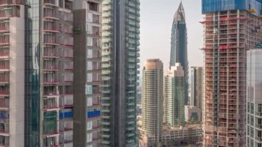 Şehir merkezindeki modern Dubai mimarisi ile havadan çekilmiş zaman çizelgesi. Bir sürü yüksek gökdelen ve kule. Hareket halindeki asansörleri olan yeni inşaat alanı.