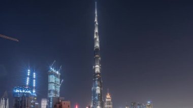Dubai şehir merkezi gökdelenleri tüm gece boyunca havadan panoramik zaman dilimi etrafında olacak. Yeni kulelerin inşaatı ve yoğun yolların trafiği. Işıklar kapanıyor.