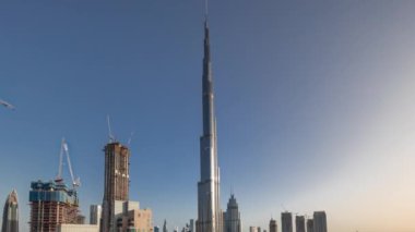 Dubai şehir merkezi en uzun gökdelenlerle tüm gün boyunca gölgeler gün doğumundan batımına hızla ilerlerken havadan panoramik zaman çizelgesi. Yukarıdan yeni kulelerin inşa alanı
