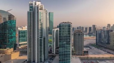 Gün batımında Dubai İş Sahası gökdelenleri ve su kanalı havadan zaman ayarlı. Karmaşık kullanım geliştirme ile konut ve ofis kuleleri aynı ayak izini paylaşıyor