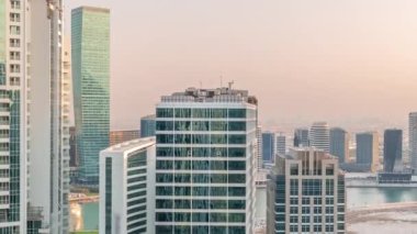 Gün batımında Dubai 'de su kanalı hava zaman ayarlı Business Bay gökdelenleri. Karmaşık kullanım geliştirme ile konut ve ofis kuleleri aynı ayak izini paylaşıyor