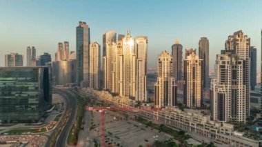 Gündoğumu sırasında Bay Bulvarı 'nda Business Bay havacılık panoramik zaman dilimi, Dubai, BAE' de modern kuleler inşa edildi. Camdan ve uzun gölgelerden yansıyan güneşli gökdelenler.