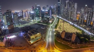 Bay Bulvarı 'nın Panorama' sı aydınlatmalı modern kuleler Business Bay 'de konut geliştirme zamanı tüm gece boyunca, Dubai, BAE. Aylı ve ışıkları sönen gökdelenler