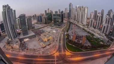 Bay Bulvarı 'nın Panorama' sı Business Bay hava sahasında gece gündüz geçiş zamanı, Dubai, BAE. Büyük otoparkın üzerinde gün doğumu olan gökdelenler